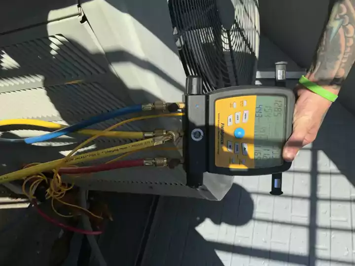 Refrigerant gauges on an outdoor condenser during a New Orleans AC repair