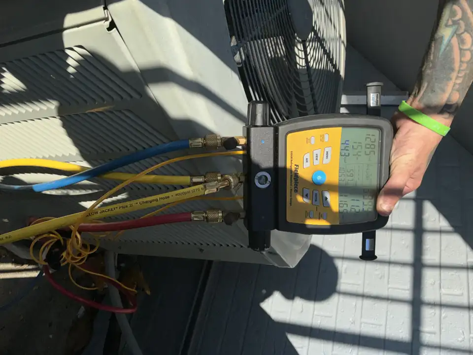 Refrigerant manifold gauges connected to an outdoor condenser