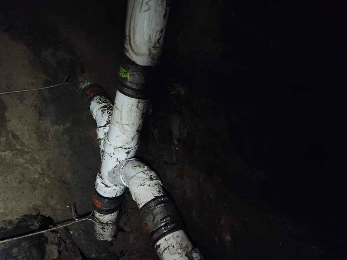 New PVC wye and shielded couplings after an underground plumbing repair in New Orleans