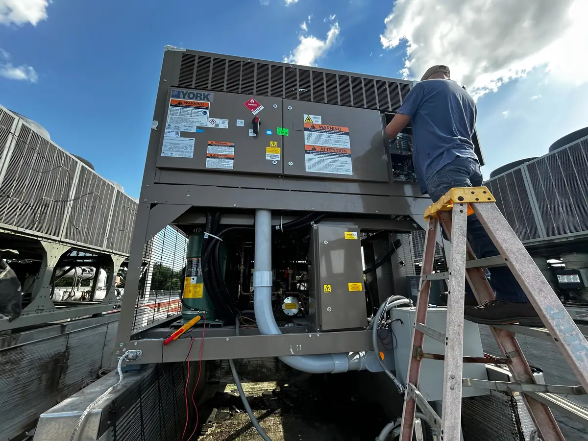 Technician servicing an open York rooftop unit